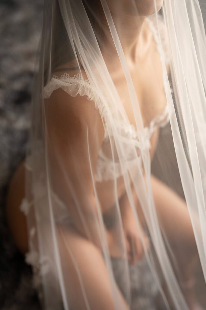 Bride posing in her veil for her bridal boudoir session.